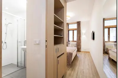 a bathroom with a sink and a door to a bedroom at Hotel Carol in Prague
