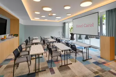 a dining room with tables and chairs and a screen at Hotel Carol in Prague