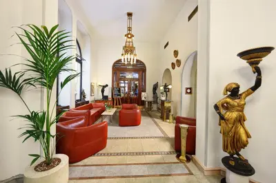 a lobby with a statue of a woman and red furniture at Hotel Paris Prague in Prague