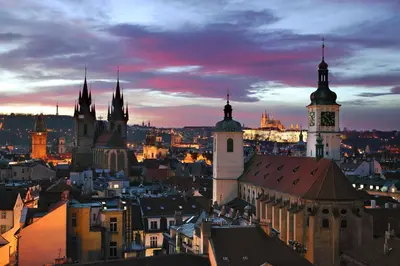 a view of a city at night with a clock tower at Hotel Paris Prague in Prague