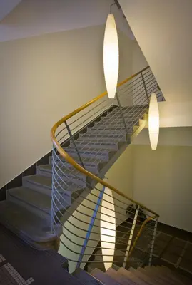 a spiral staircase with two lights on the wall at Mamaison Residence Belgická Prague in Prague