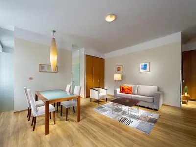 a living room with a table and chairs and a couch at Mamaison Residence Belgická Prague in Prague