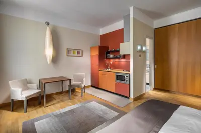 a kitchen and dining room with a table and chairs at Mamaison Residence Belgická Prague in Prague