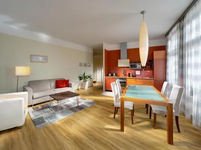 a dining room and living room with a table and chairs at Mamaison Residence Belgická Prague in Prague