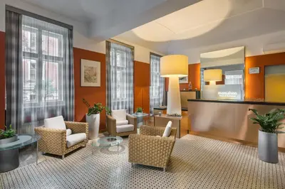 a living room with chairs and a table at Mamaison Residence Belgická Prague in Prague