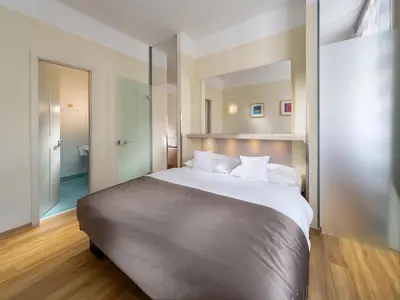 a bedroom with a large bed with a large mirror at Mamaison Residence Belgická Prague in Prague