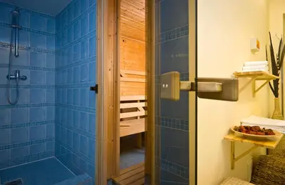 a bathroom with a shower with blue tiles at Mamaison Residence Belgická Prague in Prague