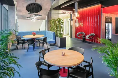 a restaurant with two tables and chairs and plants at OREA Hotel Andels Praha in Prague