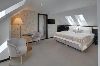 a bedroom with a bed and a table and chairs at Hotel Savoy Prague in Prague