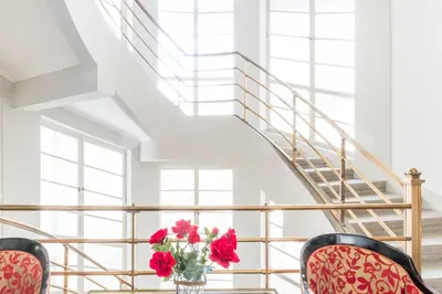 a vase of flowers sitting on a table next to a staircase at Hotel Bologna in Prague