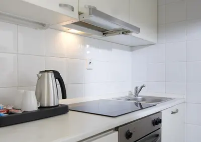 a white kitchen with a sink and a stove at Hotel Bologna in Prague