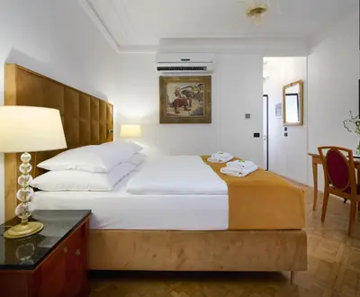 a bedroom with a large bed and a table with a lamp at Hotel Bologna in Prague