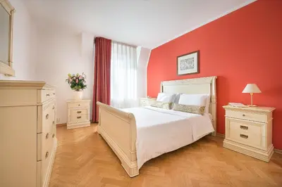 a bedroom with a white bed and a red wall at Hotel Suite Home Prague in Prague