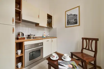 a kitchen with a stove and a table and a chair at Hotel Suite Home Prague in Prague