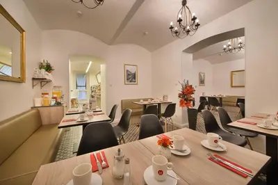 a restaurant with tables and chairs in a room at Hotel Suite Home Prague in Prague