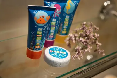 three bottles of toothpaste and flowers on a table at Hotel Suite Home Prague in Prague