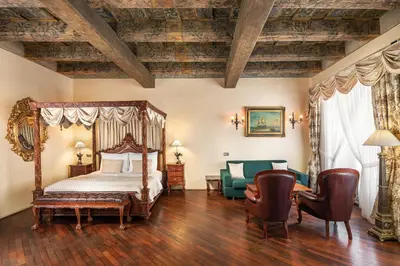 a bedroom with a bed and a table and chairs at Iron Gate Hotel & Suites Prague by BHG in Prague