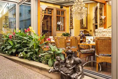 a statue of a man sitting on a bench in a restaurant at Iron Gate Hotel & Suites Prague by BHG in Prague
