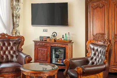 a living room with two leather chairs and a tv at Iron Gate Hotel & Suites Prague by BHG in Prague