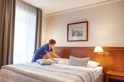 a young girl jumping on a bed in a hotel room at Adria Hotel Prague in Prague