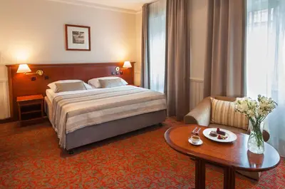 a hotel room with a bed and a table at Adria Hotel Prague in Prague