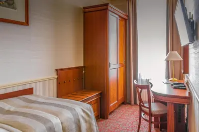 a bedroom with a bed and a desk and a table at Adria Hotel Prague in Prague