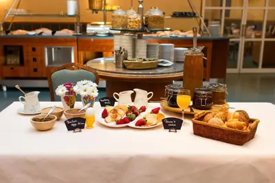 a table with breakfast foods and drinks on it at Adria Hotel Prague in Prague