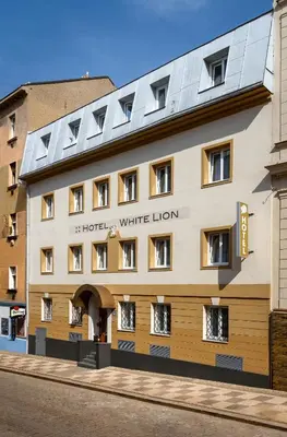 a hotel with a white lion sign on the front of a building at Hotel White Lion in Prague