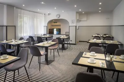 a restaurant with tables and chairs in a room at Hotel White Lion in Prague