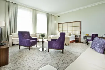 a hotel room with purple chairs and a bed at Kosher Hotel King David Prague in Prague
