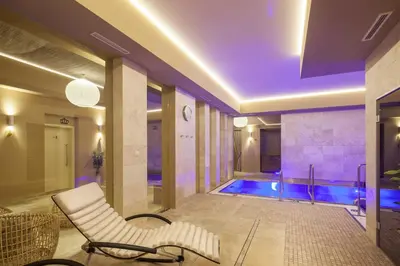a living room with a swimming pool and a chair at Kosher Hotel King David Prague in Prague