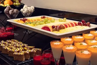 a buffet with a tray of fruit and other food at Kosher Hotel King David Prague in Prague