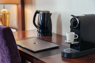 a coffee maker sitting on a table with a coffee cup at Kosher Hotel King David Prague in Prague