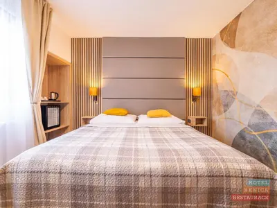 a bedroom with a large bed with yellow pillows at Hotel Benica in Benešov