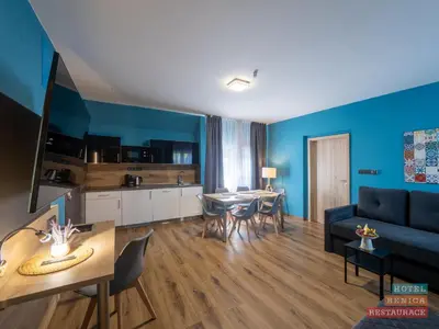 a bedroom with blue walls and a bed with a desk at Hotel Benica in Benešov