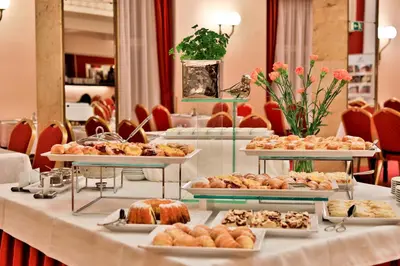 a table with several trays of pastries and desserts at Belvedere in Prague