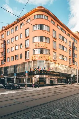 a large orange building with a hotel on a street at Belvedere in Prague