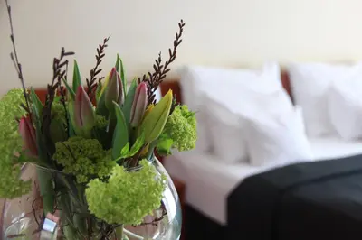 a glass vase filled with green plants in a living room at Art Hotel Prague in Prague