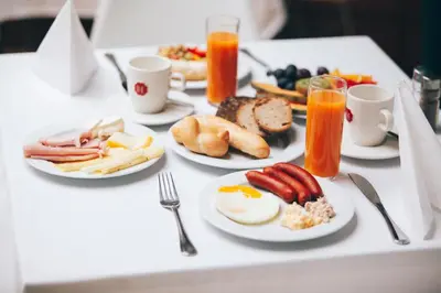 a table with plates of breakfast food on it at Art Hotel Prague in Prague