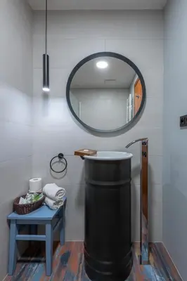 a bathroom with a round mirror and a trash can at Art Hotel Prague in Prague