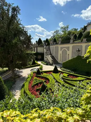 a garden with flowers and plants in front of a building at Aria Hotel Prague in Prague