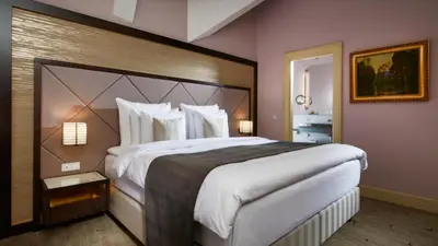 a large bedroom with a large bed with white sheets at Aria Hotel Prague in Prague