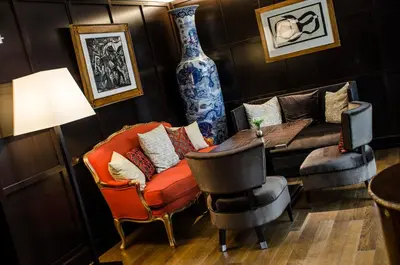 a living room with a couch and a table and chairs at Aria Hotel Prague in Prague