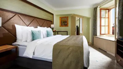 a bedroom with a large bed with white and blue pillows at Aria Hotel Prague in Prague