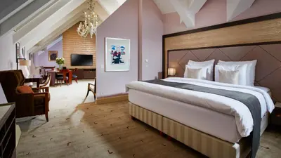 a bedroom with a large bed and a dining room at Aria Hotel Prague in Prague