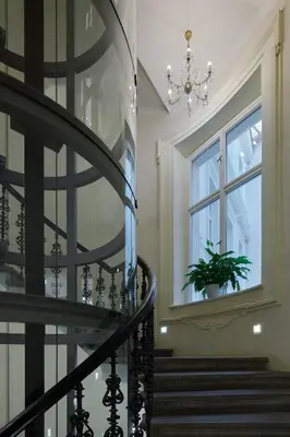 a spiral staircase with a window and a potted plant at Ventana Hotel Prague in Prague