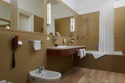 a bathroom with a sink and a toilet and a mirror at Ventana Hotel Prague in Prague