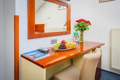 a table with a bowl of fruit and a vase of flowers at Hotel Atos in Prague