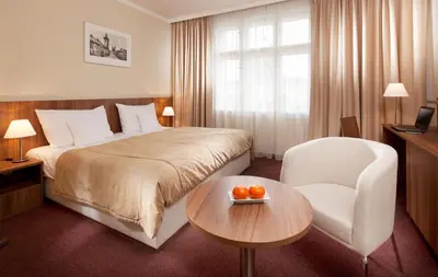 a hotel room with a bed and a table and a chair at Clarion Hotel Prague Old Town in Prague