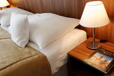 a bedroom with a bed and a table with a lamp at Clarion Hotel Prague Old Town in Prague
